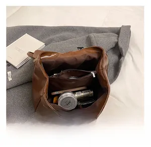 Internal view of brown large capacity bag showing inner pocket and daily essentials