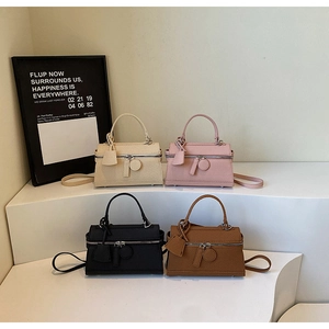 Detail view of stylish square handbags in beige pink black and brown leather textures