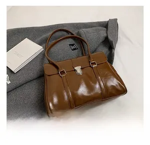 Detailed view of a brown vintage leather handbag with silver metallic buckle and double straps
