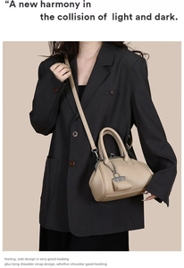 Dettaglio borsa beige in pelle a grana con chiusura metallica e ciondolo a catena