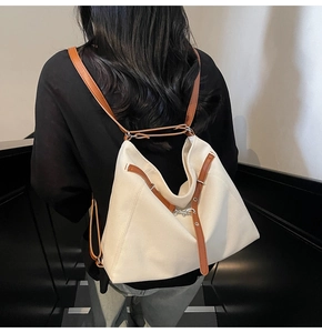 Detail of cream canvas tote bag showing thick fabric texture and brown leather straps