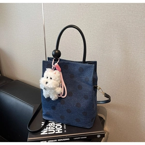 Polka dot denim handbag with round handle, plush puppy charm and pearl chain details