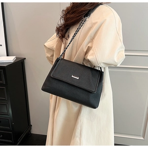 Detailed shot of a black pleated shoulder bag with silver hardware and chain strap