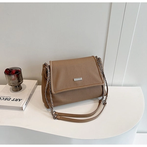 Detailed texture of brown corduroy shoulder bag with silver metal chain strap
