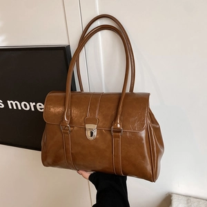 Vintage brown leather tote bag with silver metal lock and top handles for daily commute