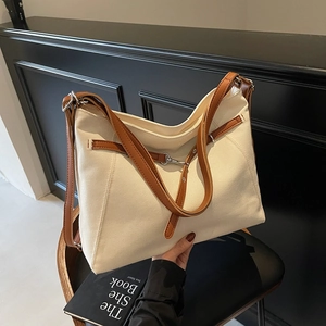 Cream canvas tote bag with brown leather straps for commuting and daily use