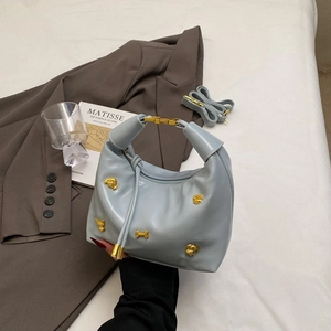 Chic light blue hobo bag with gold puppy accents on a vintage background