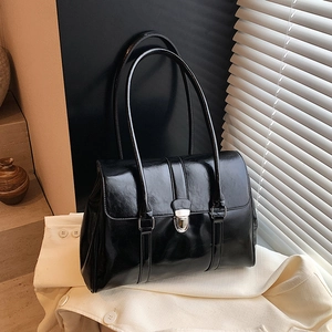 Retro black oil wax leather shoulder bag with silver buckle on a stylish cream fabric