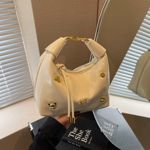 Chic off-white leather handbag with unique gold dog and bone metallic studs