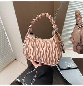 Dettaglio della borsa hobo rosa a pieghe con manico arricciato e finiture in metallo