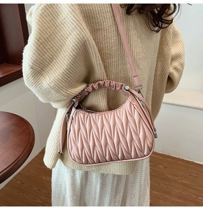 Dettaglio borsa a mano rosa con texture increspata matelassé e tracolla rimovibile