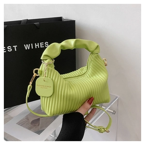 Detail of ruched light green handbag with gold hardware and leather fashion tag