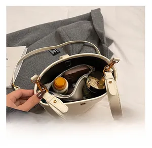 Intérieur spacieux du sac seau en cuir blanc montrant les articles et la capacité