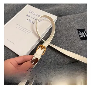 Détail de la bandoulière réglable en cuir blanc cassé avec boucle en métal doré