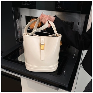 Gros plan sur le sac seau en cuir blanc cassé avec une boucle en métal doré élégante