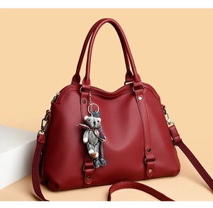 Detail of lychee pattern leather handbag with silver hardware and bear charm pendant