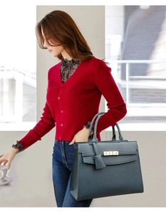 Detailed view of the pebbled leather texture and gold twist-lock on a chic tote bag