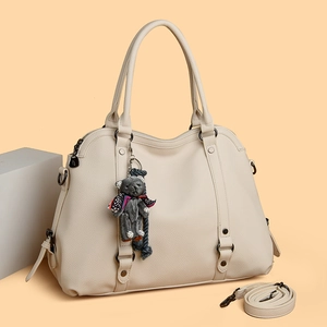 Minimalist beige lychee grain handbag with shoulder strap and cute bear charm accessory