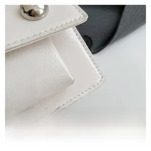 Close-up of white leather texture with fine stitching and silver metal buckle detail