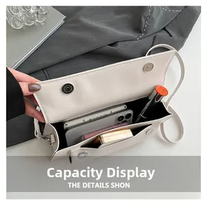 Interior view showing the capacity of a white leather baguette bag for essentials