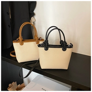 Close-up of mini woven bucket bags with knotted leather handles and crossbody straps