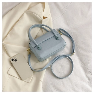 Close-up of light blue lychee pattern PU leather handbag with gold hardware details