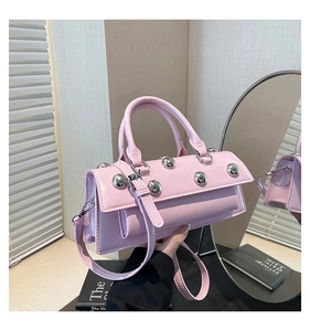 Pink polished leather handbag with large silver rivets and adjustable shoulder strap
