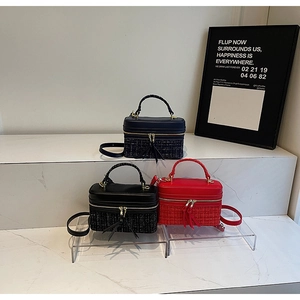 Vue détaillée de sacs boîte bicolores en patchwork de cuir et tweed avec des pompons
