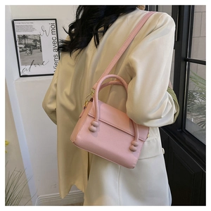 Detailed view of pink textured leather handbag with unique spherical decorative handle fasteners