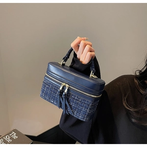 Détail du sac bandoulière patchwork en tweed et cuir avec zip doré et glands