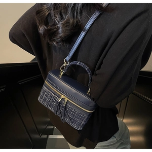 Détail du sac boîte bleu marine montrant la texture tweed et la fermeture éclair dorée
