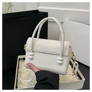 Close-up of white lychee texture handbag with elegant double-layer bead handle detail