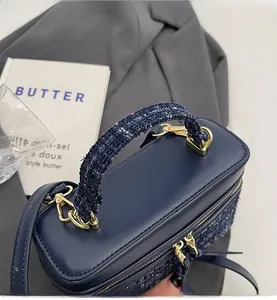 Détail du sac à main en tweed bleu foncé et cuir avec crochets métalliques dorés chic
