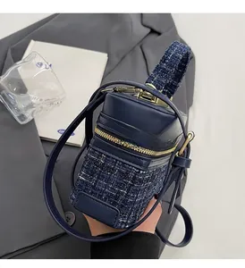 Détail du sac bandoulière en tweed avec cuir bleu marine et finitions métalliques dorées