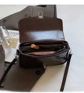 Interior view of brown faux leather crossbody bag showing main compartment and zipper pocket