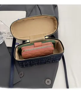 Détail de l'intérieur du sac en tweed montrant l'espace pour téléphone et portefeuille
