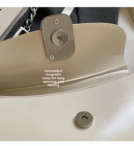 Detail of invisible magnetic closure and premium beige leather on saddle crossbody bag