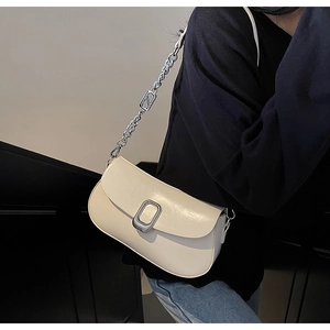 Detail of off-white leather shoulder bag with silver buckle and chain on model