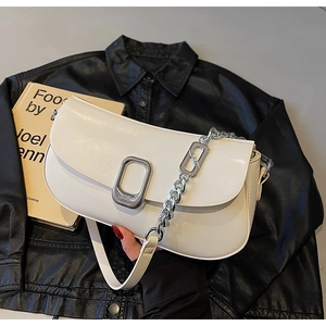 Detail of cream white leather shoulder bag with vintage buckle and silver chain strap