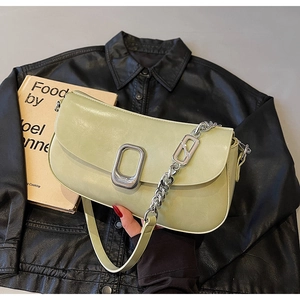 Close-up of pistachio green leather shoulder bag with silver chain and metal buckle