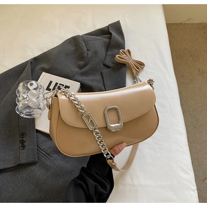 Detail of apricot soft leather bag with silver chunky chain and minimalist buckle