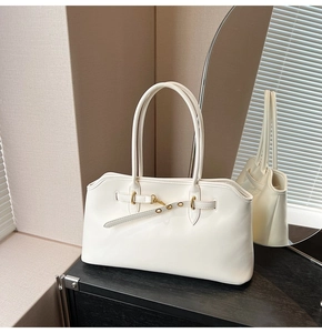 Detailed view of white vintage shell bag with gold hardware and elegant double handles