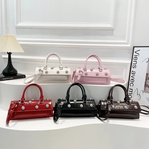 Polished baguette handbags with silver rivets in five colors on a white staircase