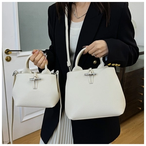 Detail view of white lychee pattern leather bucket bags with silver bamboo buckle