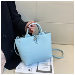Detail view of sky blue lychee grain leather tote with a silver toggle closure