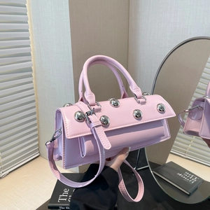 Pink motorcycle bag with metallic silver studs shown in a modern interior setting
