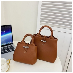 Detail of brown lychee grain leather tote bags with bamboo-shaped metal toggle closure