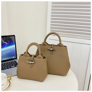 Detail of lychee pattern leather bucket bag with iconic bamboo-style metal buckle