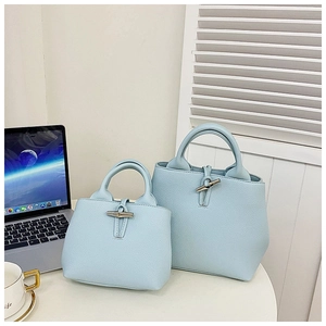 Detail view of light blue lychee-textured bucket bags with elegant silver horn buckles