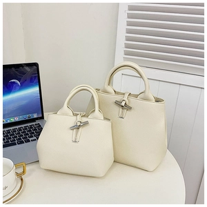 Detail of cream-white lychee grain tote bags with silver bamboo toggle closure in office setting